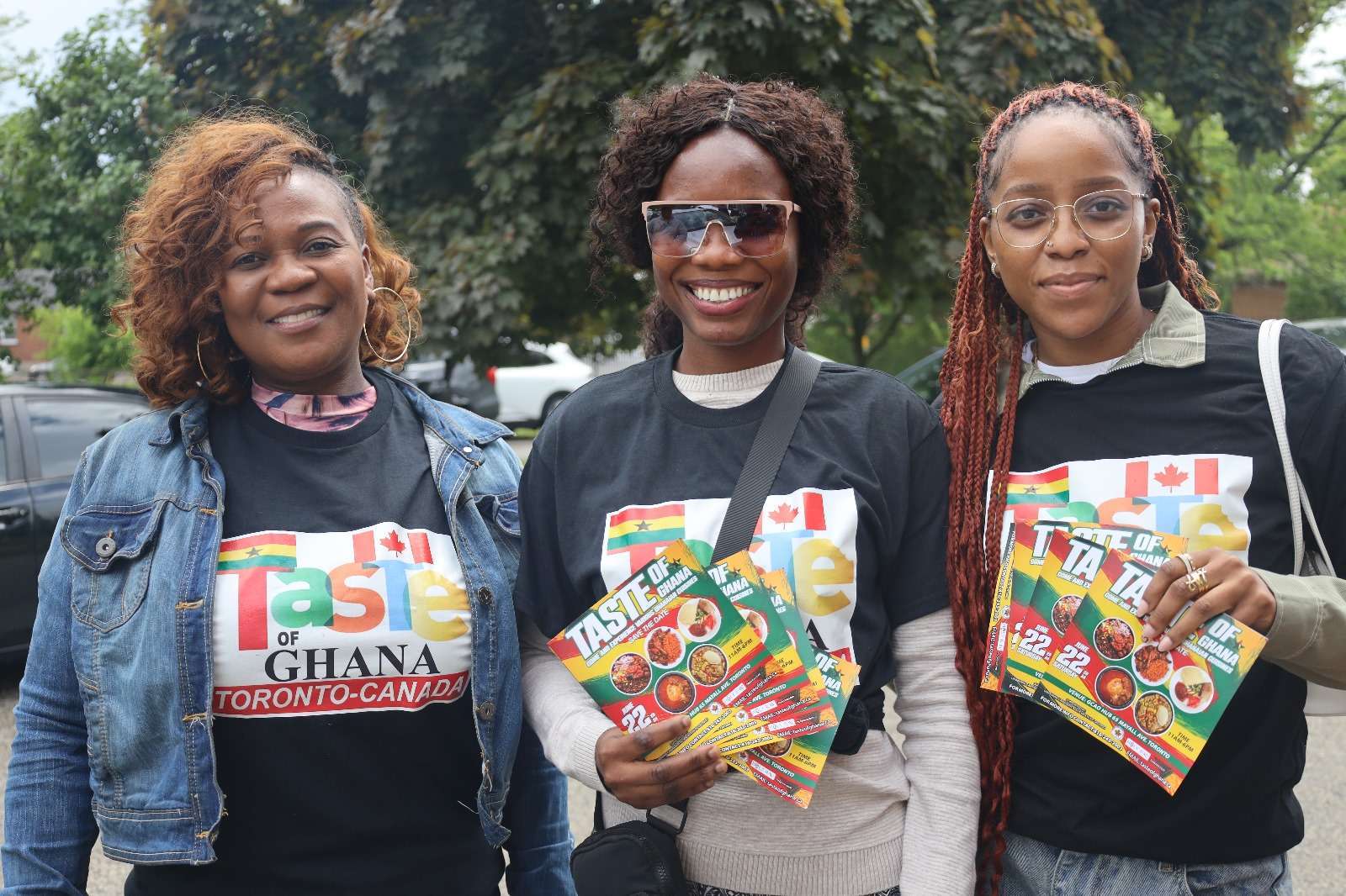 Three GCAO community members sharing Taste of Ghana information at an outdoor event